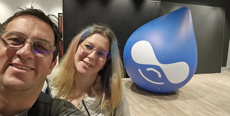 Anilu y camoa in a selfie with the Drupicon behind threm, at DrupalCon Lille 2023